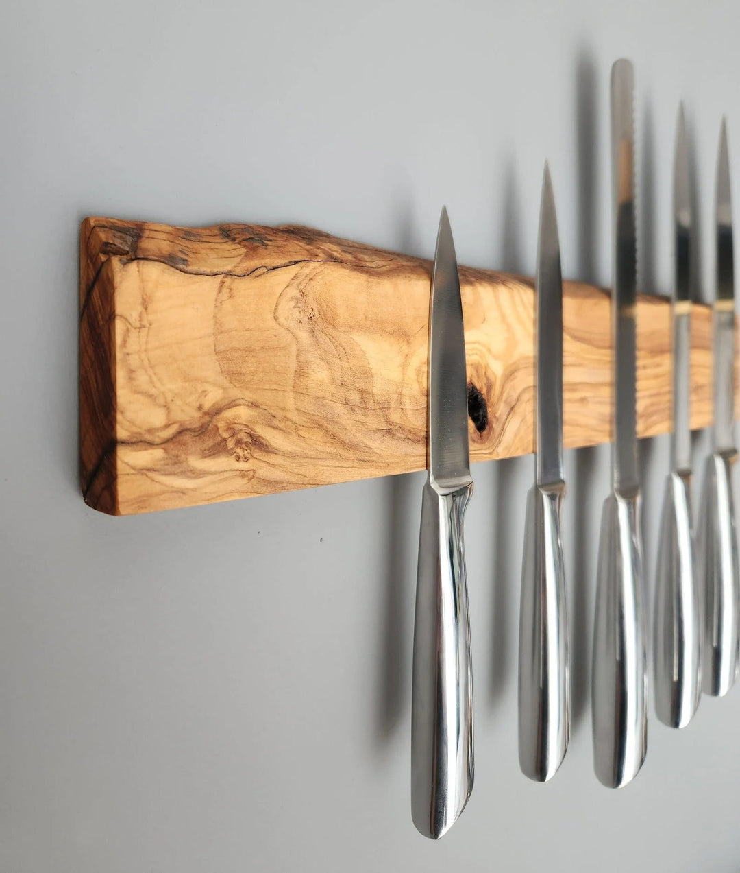 Close-up of the olive wood knife holder showing magnetic strips and wood grain